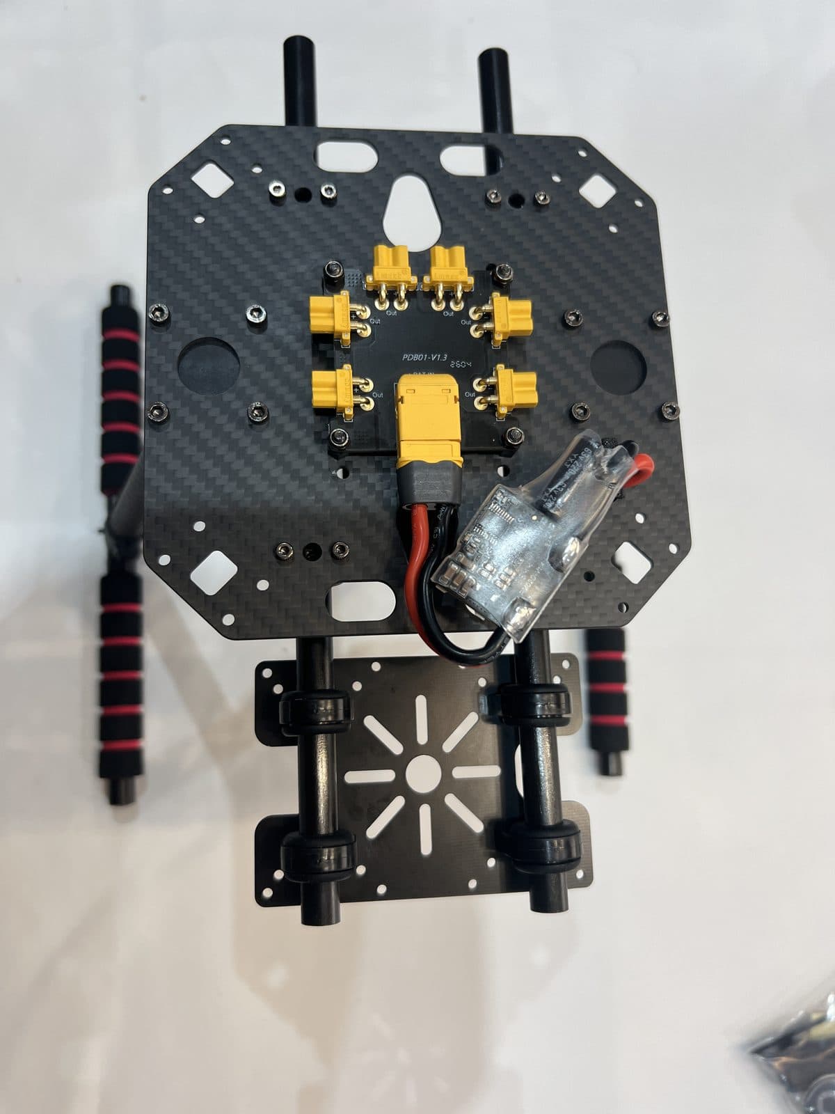 Placa central del chasis con la PDB atornillada y el primer brazo ya acoplado
