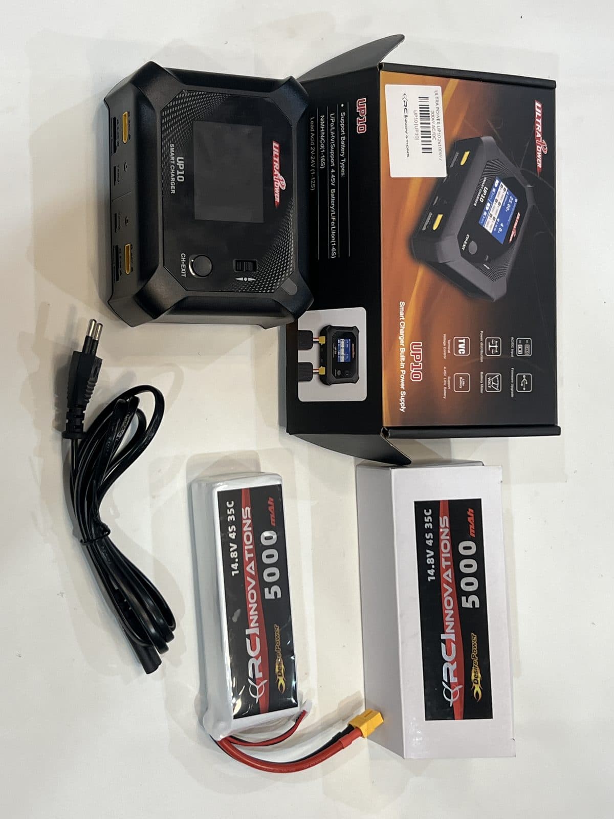 Batería LiPo 4S y cargador balanceador Ultra Power UP10, junto a los cables de carga